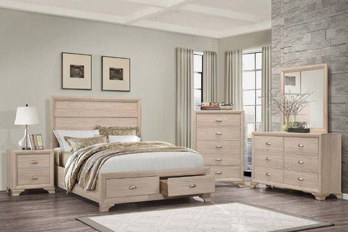 Beige bedroom set with bed, nightstand, dresser with mirror and a chest in a room with gray walls and a stone wall.