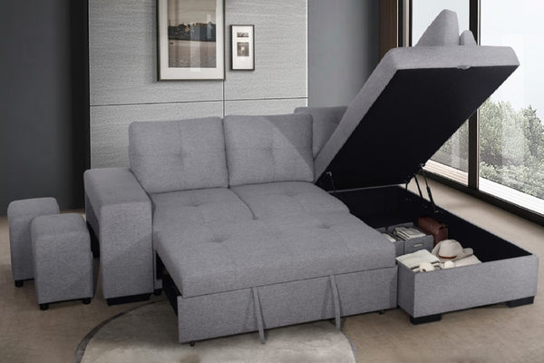 Seccional gris con otomana de almacenamiento en una habitación con ventana y arte de pared.