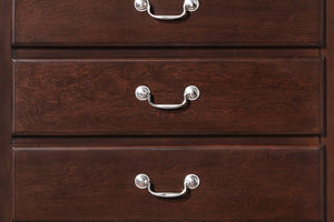 Primer plano de un chest de madera con tres gavetas y tiradores de metal.