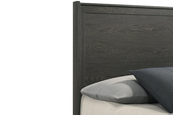 Closeup view of the top left corner of the wooden headboard with pillows on a bed against a white background.