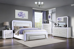 Modern bedroom with white furniture featuring a bed, a dresser with mirror, a chest and a nightstand with LED lights.