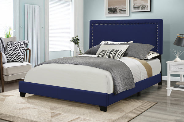 Blue upholstered bed with gray bedding in a bedroom setting.