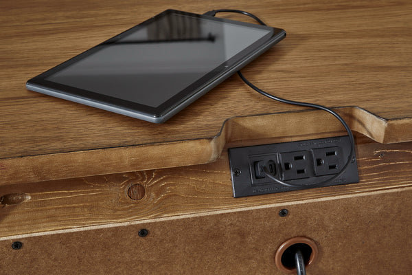 Tablet charging from a power outlet on the wooden surface of the nightstand.