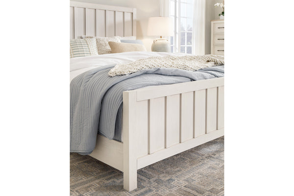 Closeup of white bed with bedding in a bedroom setting.