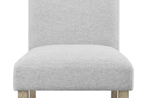 Silla tapizada gris con patas de madera sobre fondo blanco.