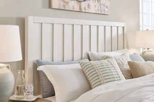 Closeup of neatly made bed with decorative pillows in a bedroom setting.