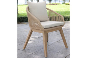 Beige, wooden and woven chair with white cushion and armrests on a patio