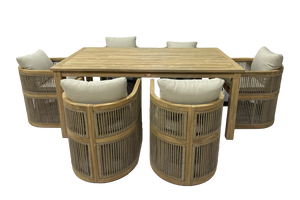 Beige wooden dining table with six matching beige and woven chairs with white cushions on a white background