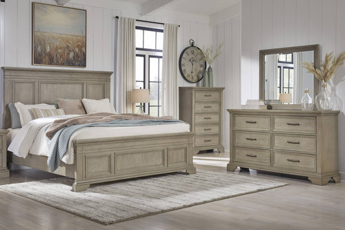 Rustic bedroom set featuring a bed, dresser with mirror, a nightstand and a chest in a well-lit room.
