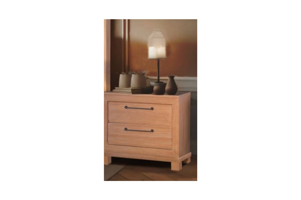 A wooden nightstand of two drawers with black handles in a room setting.