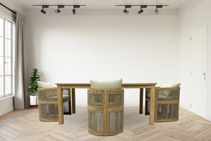 Wooden dining table with four chairs in a minimalistic room inside a house.