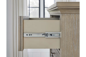 Sideview of open drawer of rustic, wooden nightstand with a bedroom setting in the background.