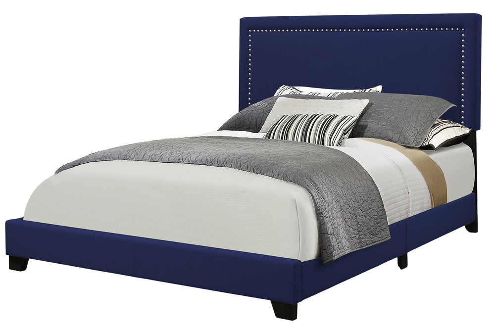 Bed with blue upholstered headboard and multicolored bedding on a white background