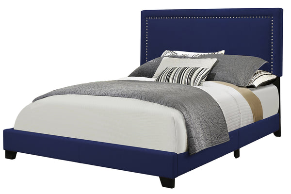 Bed with blue upholstered headboard and multicolored bedding on a white background