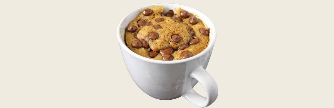 Mezcla de galleta de chocolate chip servido en un vaso blanco sobre un fondo crema.