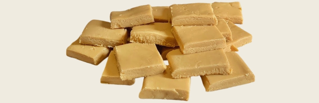 Cuadros de dulce de leche sobre un fondo crema.