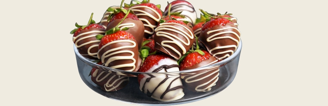 Fresas cubiertas en chocolate servido en un plato transparente sobre un fondo crema.