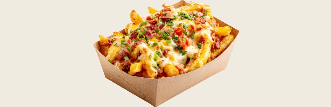 Papas fritas con queso y tocineta por encima servido en un envase de papel sobre un fondo crema.