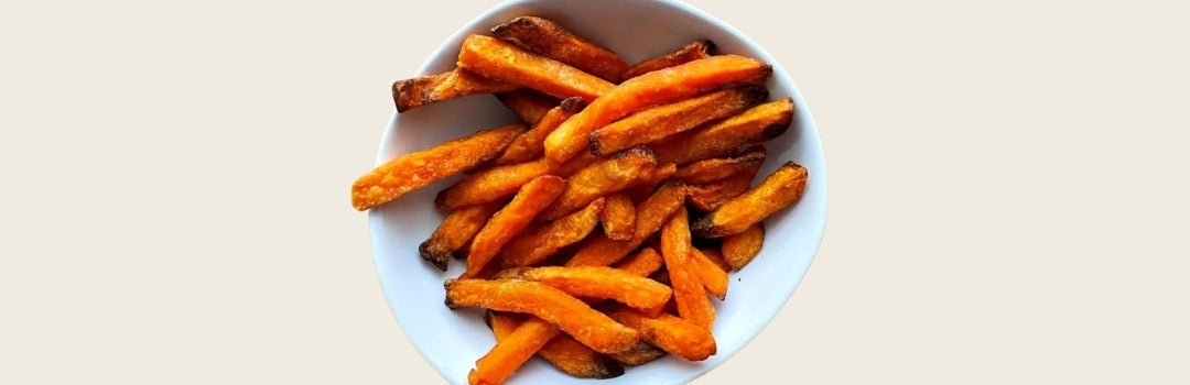 Papitas de batatas servido en un plato blanco sobre un fondo crema.