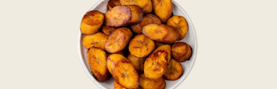 Plátanos maduros servidos en un plato grande sobre un fondo crema.