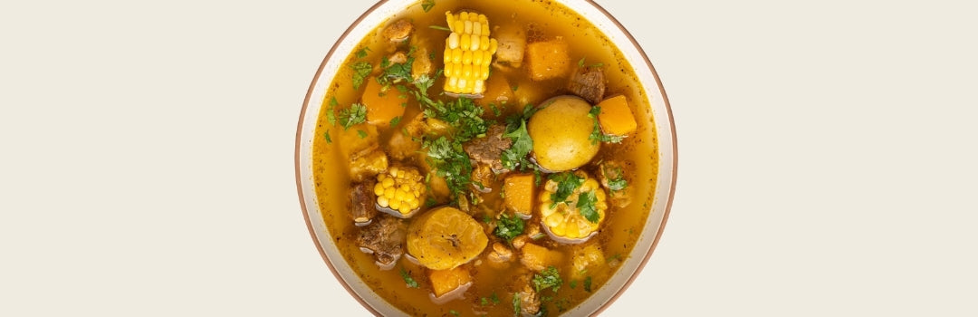 Sancocho en un plato grande sobre un fondo crema.