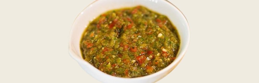 Sofrito servido en un plato pequeño blanco sobre un fondo crema.