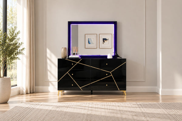 Gavetero moderno de color negro con líneas geométricas doradas y tiradores dorados, combinado con un espejo rectangular a juego con borde de luz LED morada, ubicado en un dormitorio luminoso.