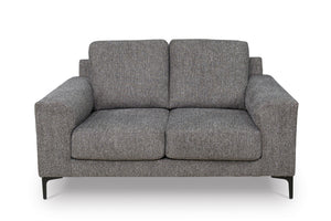 Loveseat de color gris con patas acabadas en negro sobre un fondo blanco. 