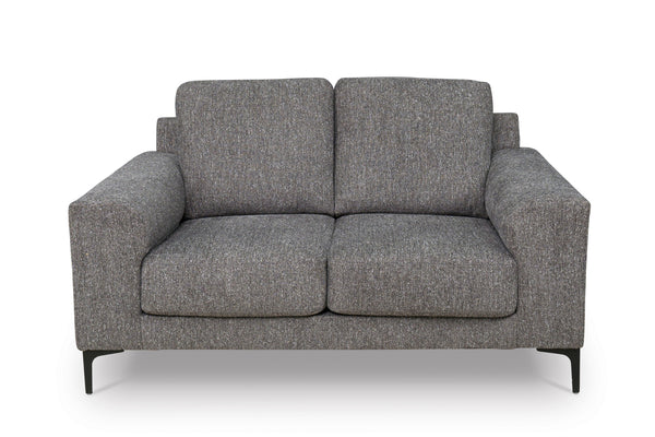 Loveseat de color gris con patas acabadas en negro sobre un fondo blanco. 
