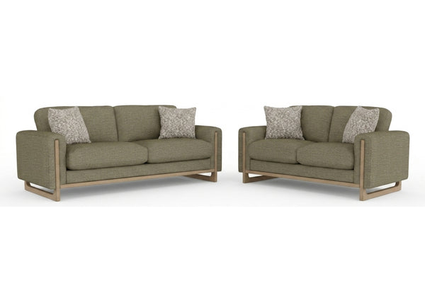 Juego de sala contemporáneo con sofá y loveseat tapizados en tela verde oliva, cojines decorativos texturizados y estructura con detalles de madera clara, presentado sobre fondo blanco.