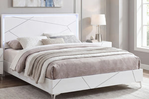 Una moderna estructura de cama blanca con paneles geométricos y retroiluminación LED integrada, decorada con ropa de cama en tonos beige y gris neutros en un dormitorio luminoso.