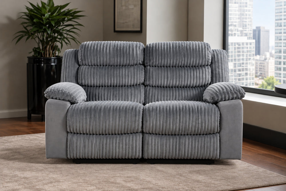 Loveseat reclinable de corduroy gris colocado en una sala moderna con una ventana con vista a la ciudad, planta en maceta y alfombra.