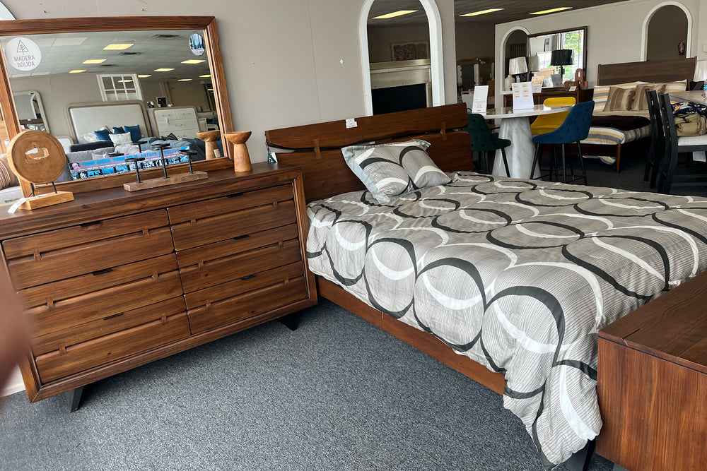 Conjunto de habitación marrón que incluye una cama, un gavetero con espejo y dos mesas de noche con elementos decorativos. 