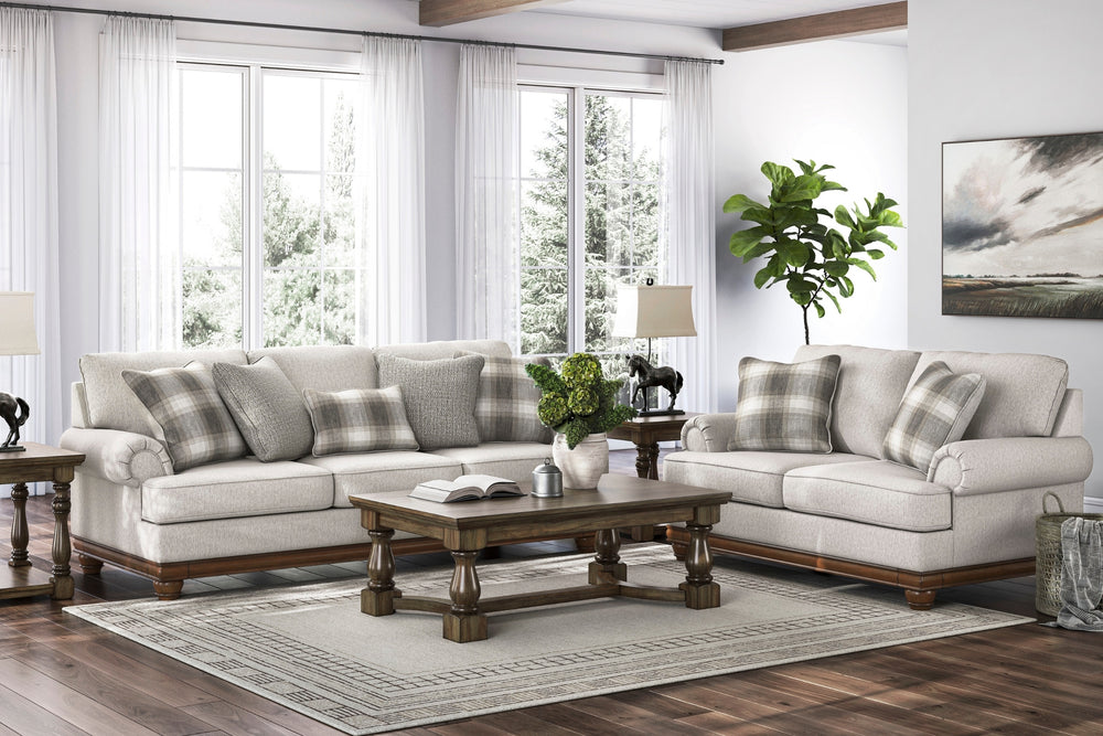 Sofás y loveseat gris claro con cojines a cuadros sobre un fondo blanco.