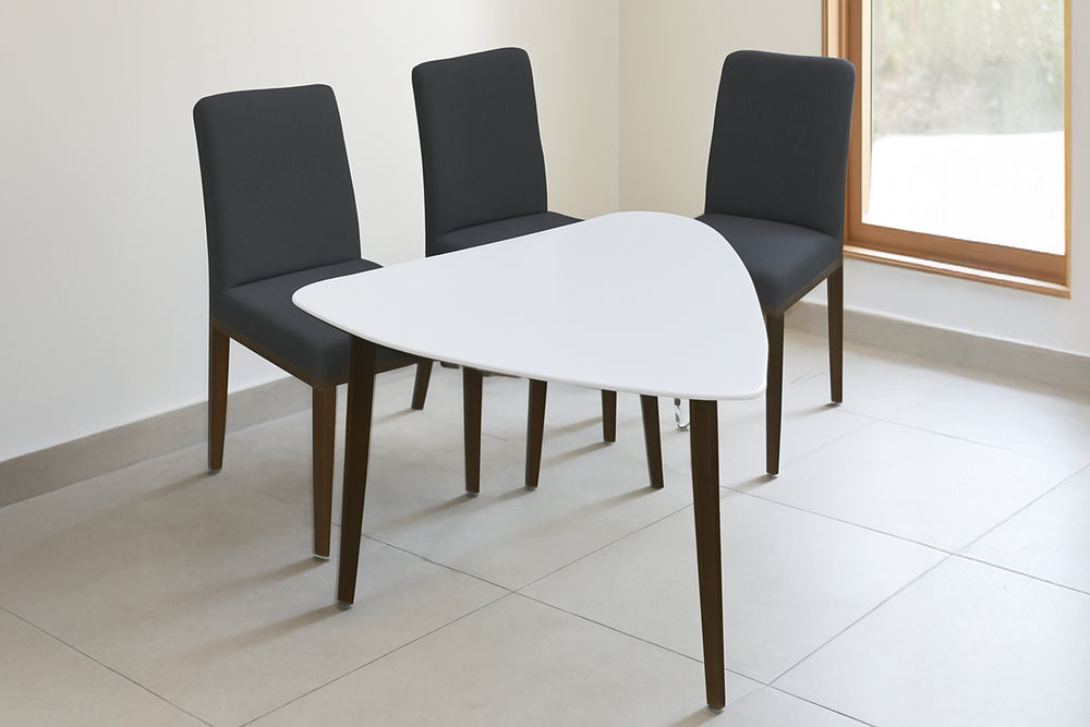 Mesa gris triangular con tres sillas con acolchado gris oscuro con respaldar en fondo blanco. 