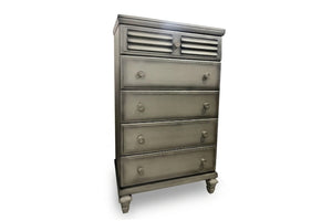 Chest de color gris con cinco gavetas con manijas redondas sobre un fondo blanco. 