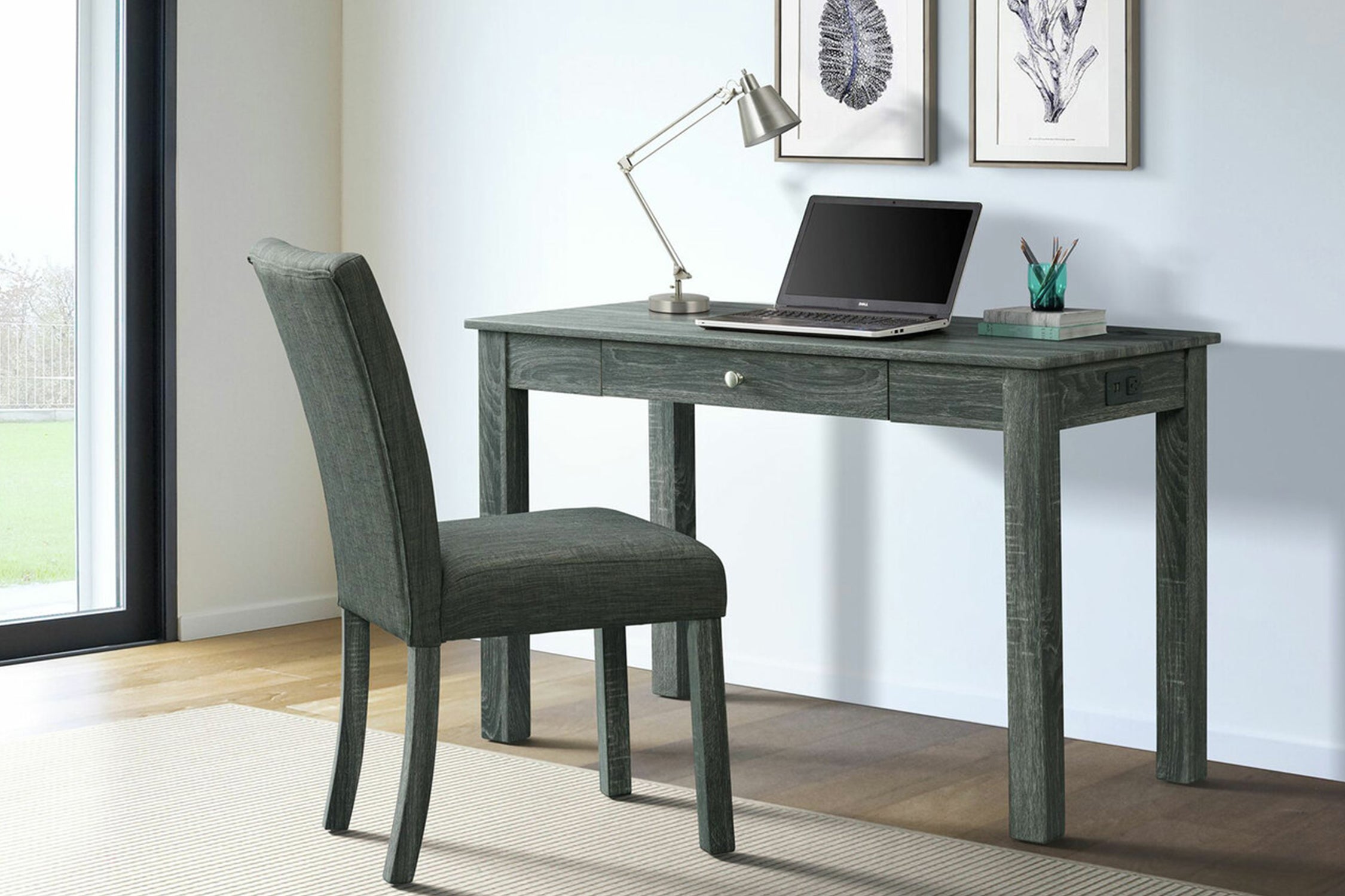 Escritorio de madera verde grisáceo con una gaveta y con una silla en una oficina con elementos decorativos. 