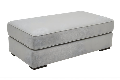 Otoman de color gris claro de forma rectangular con patas cuadradas y bajitas sobre un fondo blanco. 