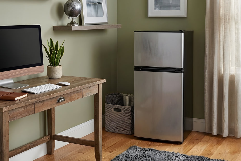 Nevera marca 'Midea' de acero inoxidable plateado sobre un fondo blanco. 