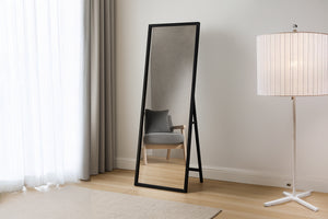 Espejo tipo caballete con superficie texturizada en una habitación neutral. 