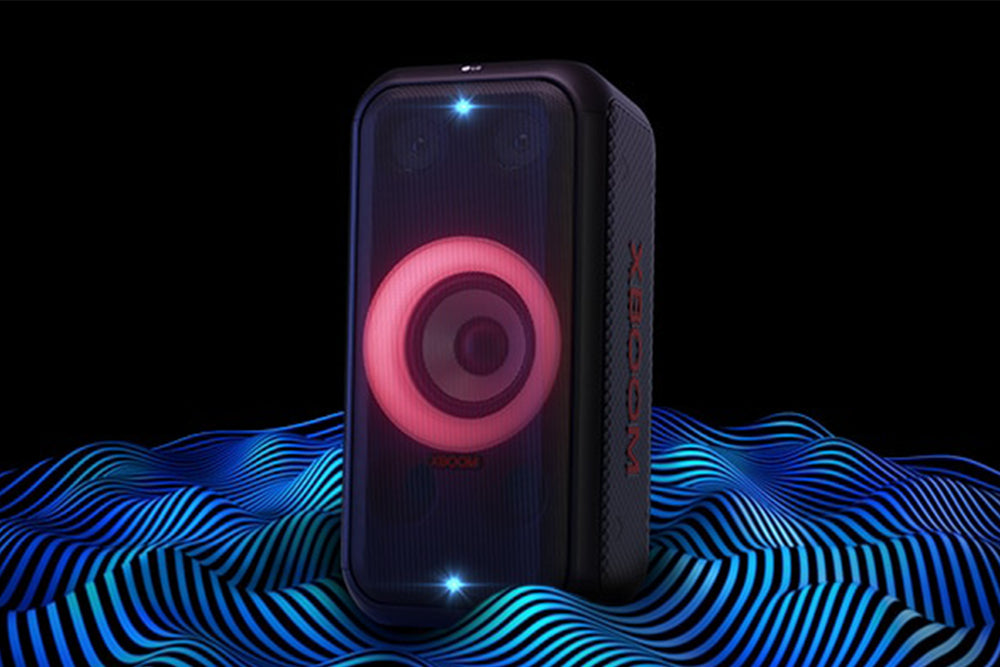 Altavoz portátil negro con luces LED de colores sobre fondo blanco.