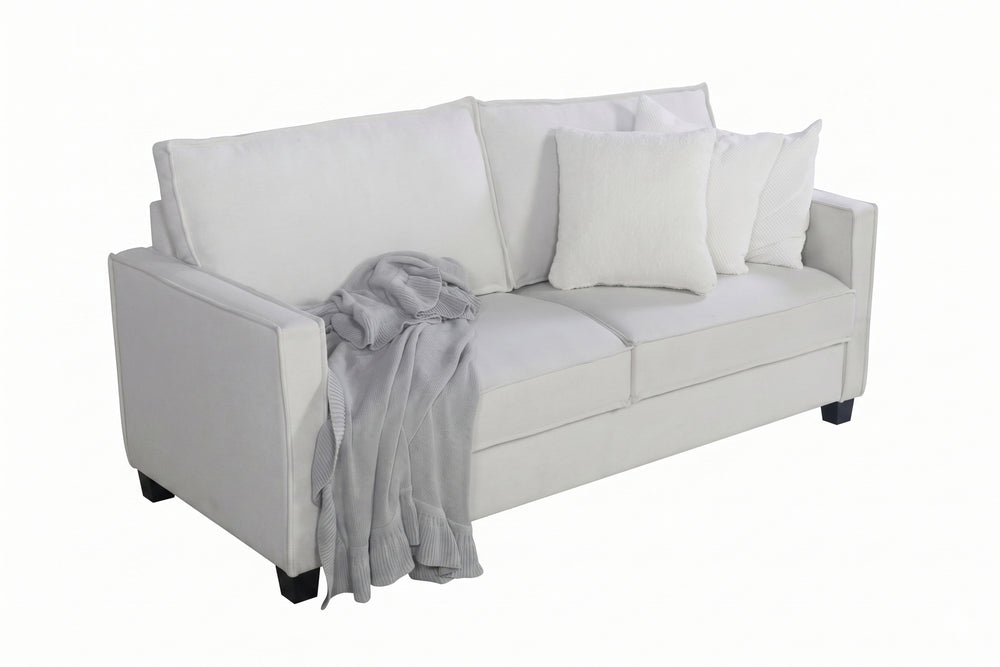 Loveseat beige con cojines blancos y una manta gris sobre un fondo blanco.