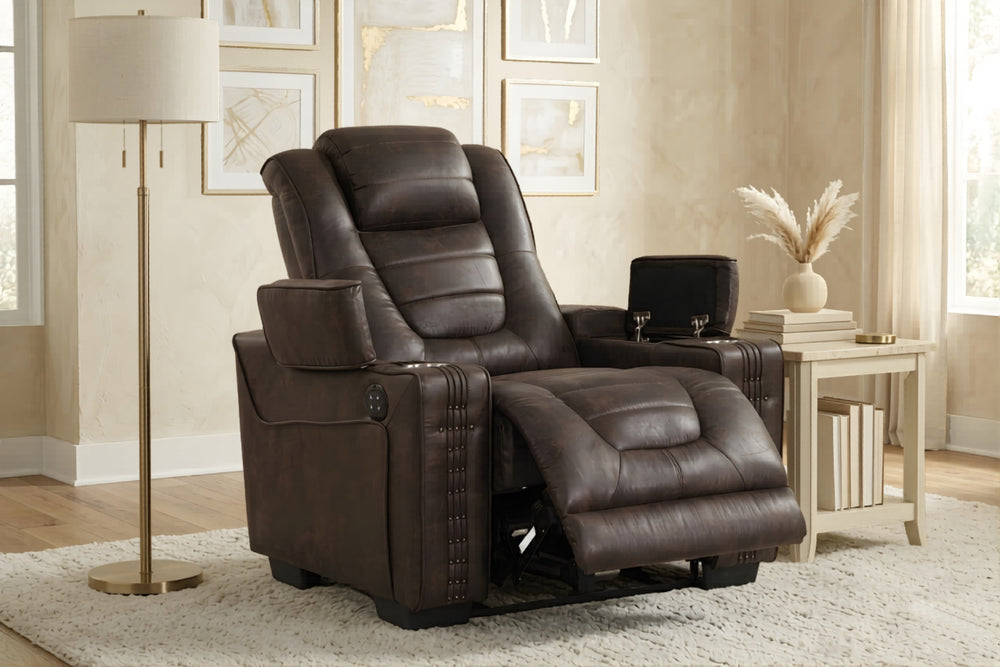 Butaca reclinable de cuero de color marrón oscuro con brazos con almacenamiento y un reposapiés ajustable sobre un fondo blanco. 