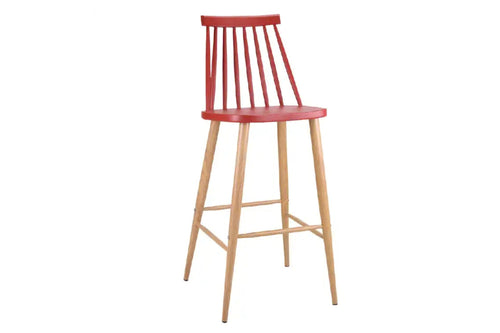 Taburete rojo con patas acabadas en marrón y con reposapiés y respaldar en un fondo blanco. 