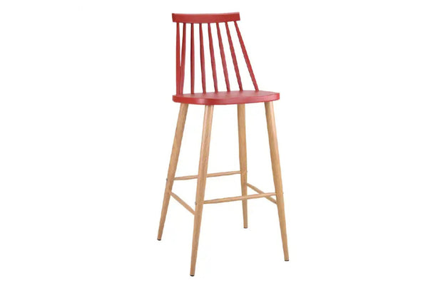 Taburete rojo con patas acabadas en marrón y con reposapiés y respaldar en un fondo blanco. 