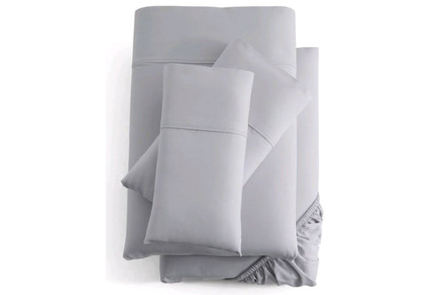 Juego de cama gris que incluye sábana ajustable, sábana encimera y fundas de almohada sobre fondo blanco.