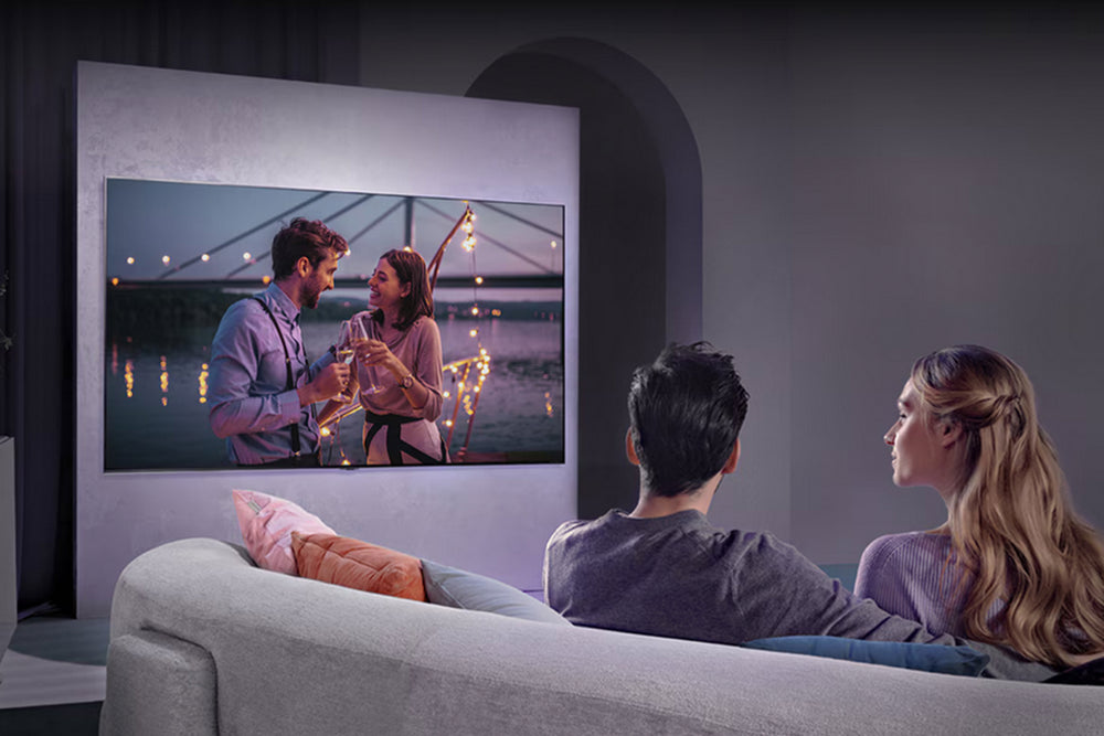 Televisor LG QNED que muestra un paisaje abstracto colorido con '65"' en pantalla.