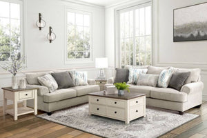 Sala de estar con sofá y loveseat, mesa de centro y objetos decorativos.