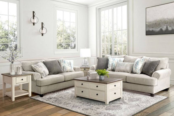 Sala de estar con sofá y loveseat, mesa de centro y objetos decorativos.
