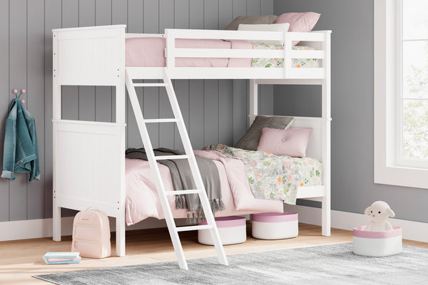 Cama alta blanca con ropa de cama rosa en una habitación con paredes grises y una ventana.